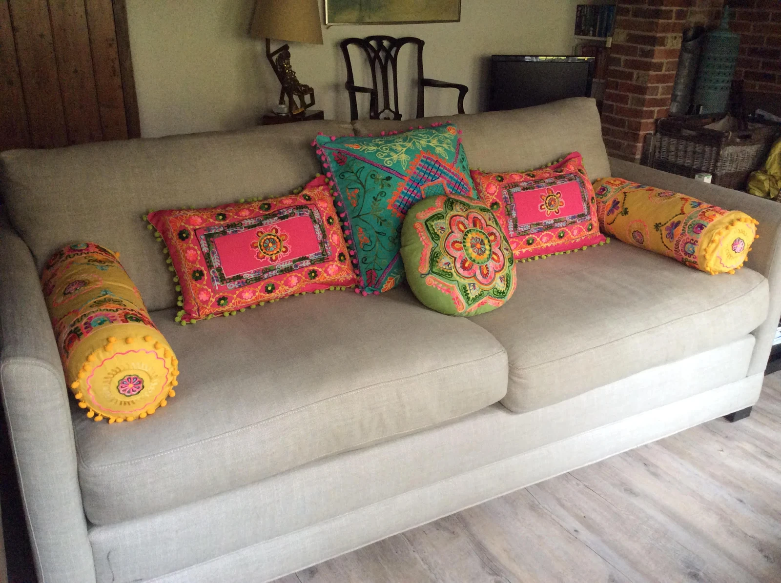Colourful embroidered cushions on an upholstered sofa