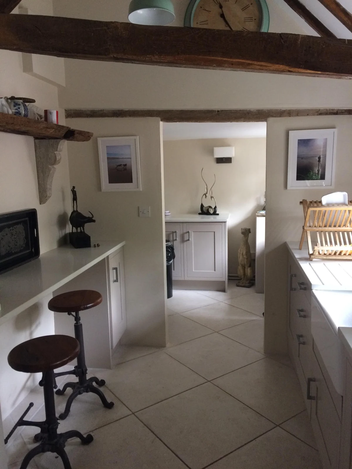 Light kitchen with painted cabinetry and exposed beams